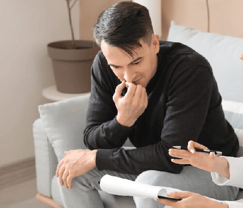 Man in a mental health and addiction rehab treatment facility meeting with a therapist