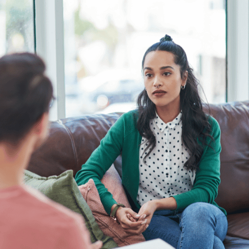 A young woman meets with her therapist to discuss the cost of addiction therapy and counseling without insurance