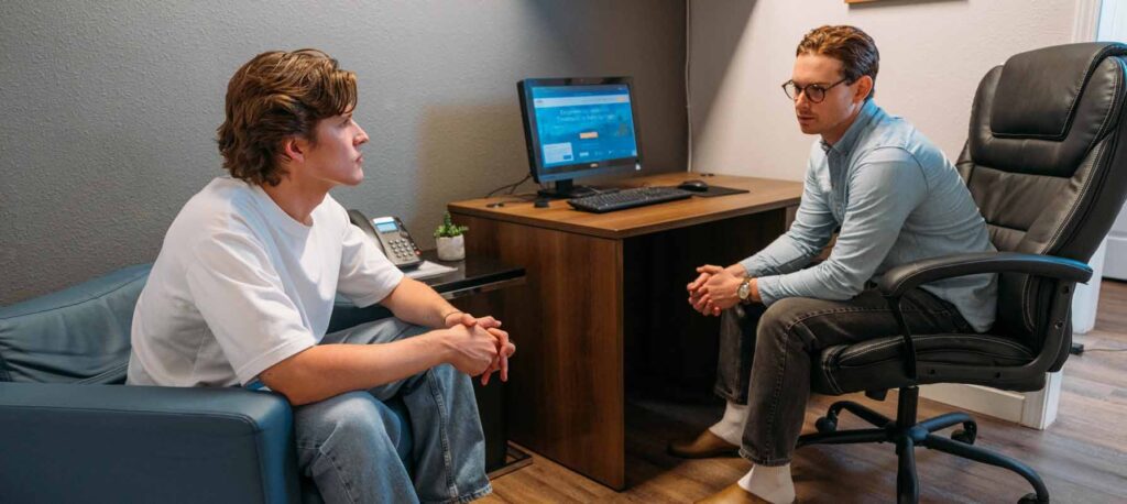 A therapist listens to a client at a substance addiction rehab center