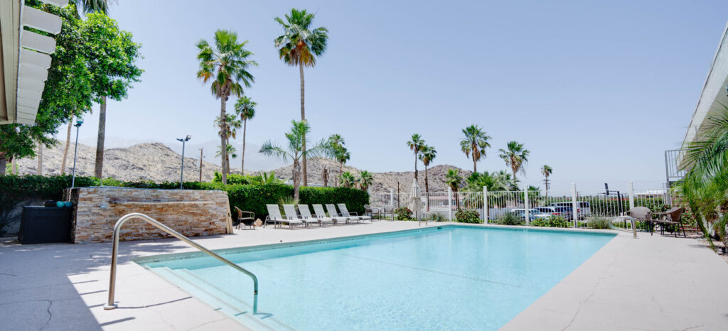 Outdoor pool, palms, and hills view at California Behavioral Health, a substance addiction rehab retreat